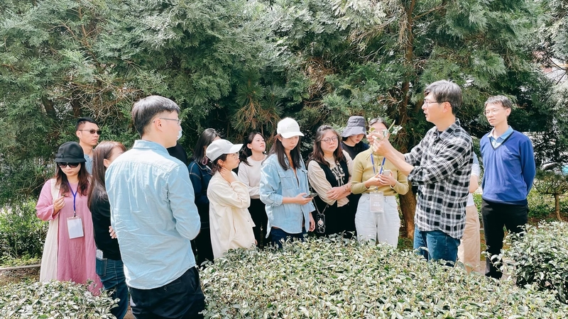 茶葉感官品評中級班課程實景,講師於茶園中講解茶樹管理、病蟲害辨識與製茶技術,帶領學員從產地實務理解茶葉評鑑與品質判斷重點